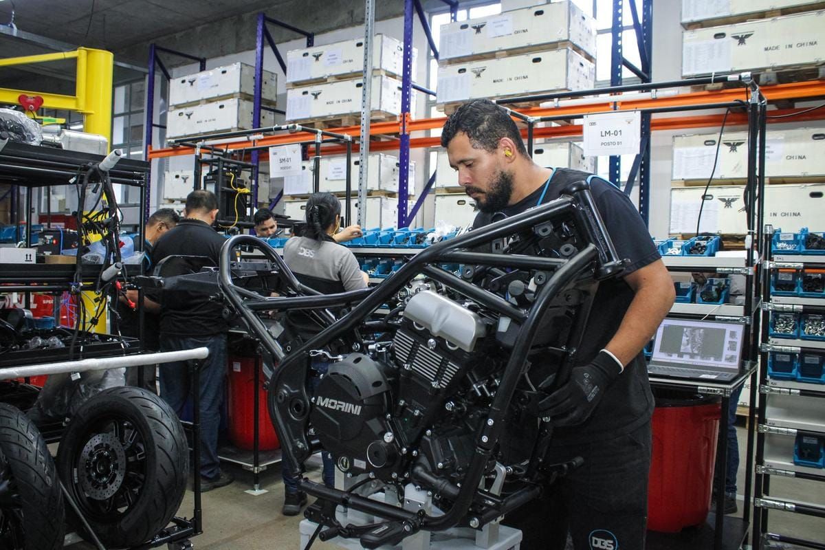 Homem montando o motor e chassi de uma motocicleta Moto Morini em linha de produção da DBS, em Manaus