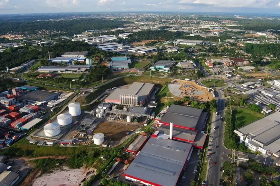 Vista aérea de fábricas e galpões do Polo Industrial de Manaus, com vegetação e ruas ao redor