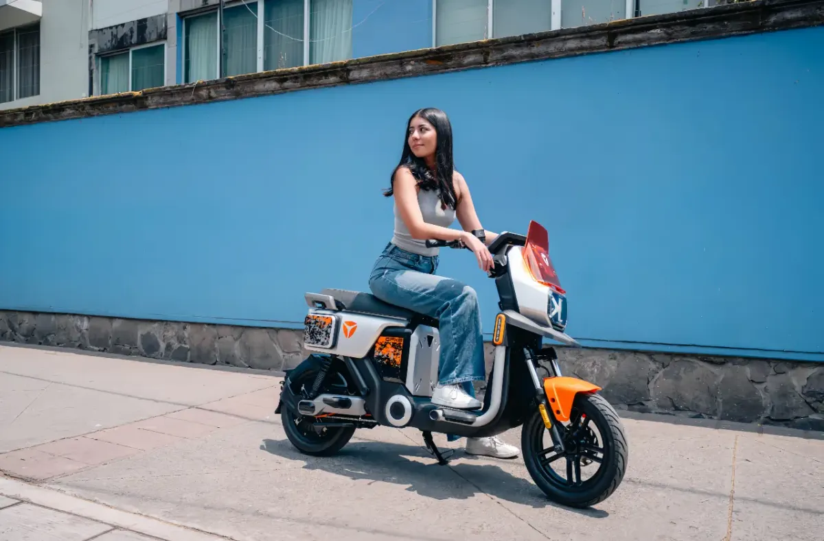 Pessoa andando de bicicleta elétrica em uma rua da cidade, com prédios ao fundo