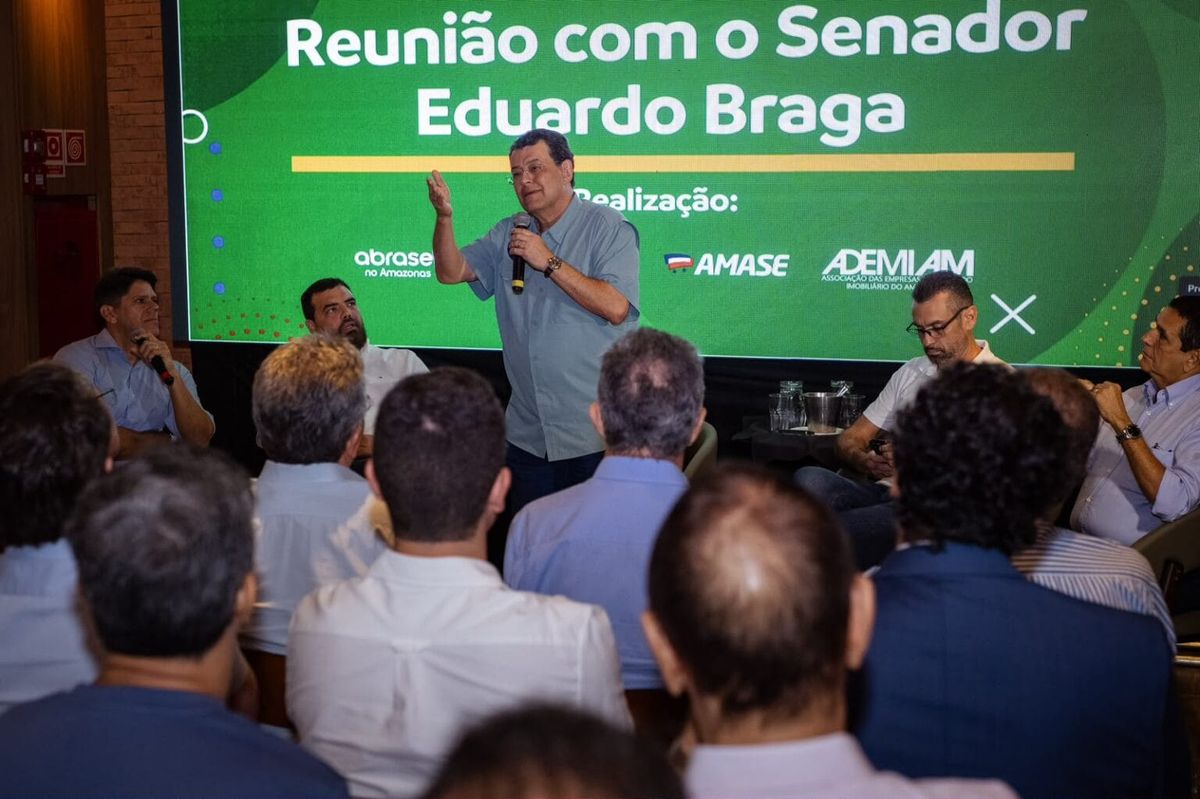 Senador Eduardo Braga fala ao microfone durante reunião com empresários em Manaus.