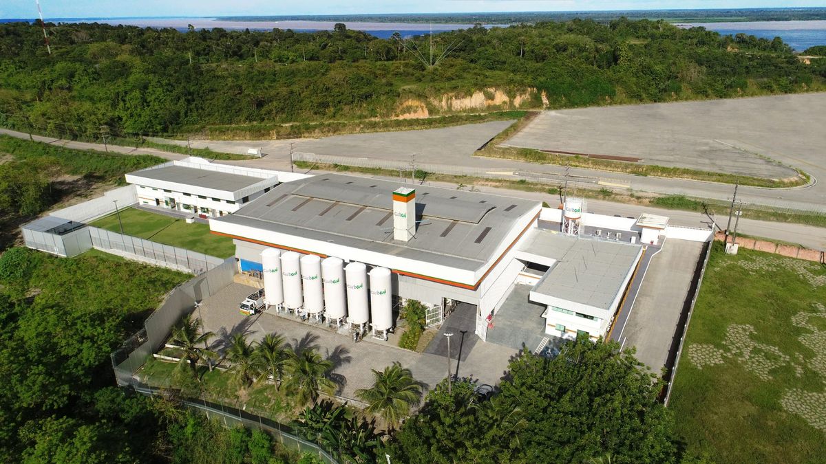 Vista aérea da unidade industrial da Carboxi em Manaus, com tanques brancos de armazenamento e prédios administrativos.