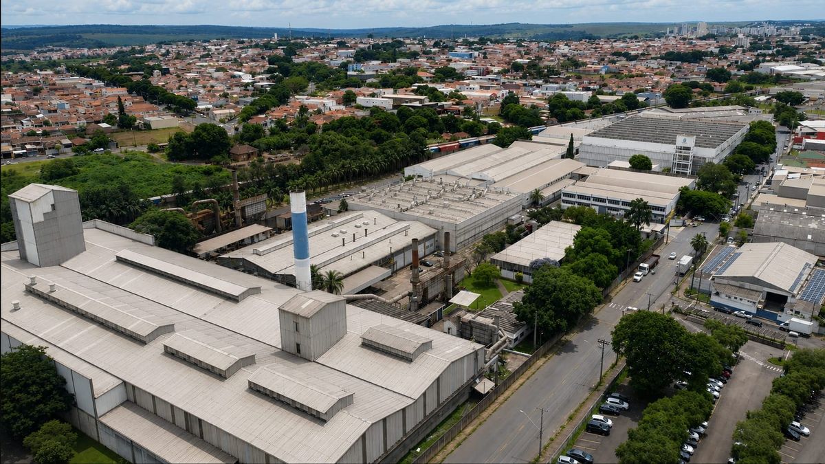 Vista aérea do complexo industrial da fábrica da Tecumseh, com galpões de telhado cinza rodeados por árvores e ruas.