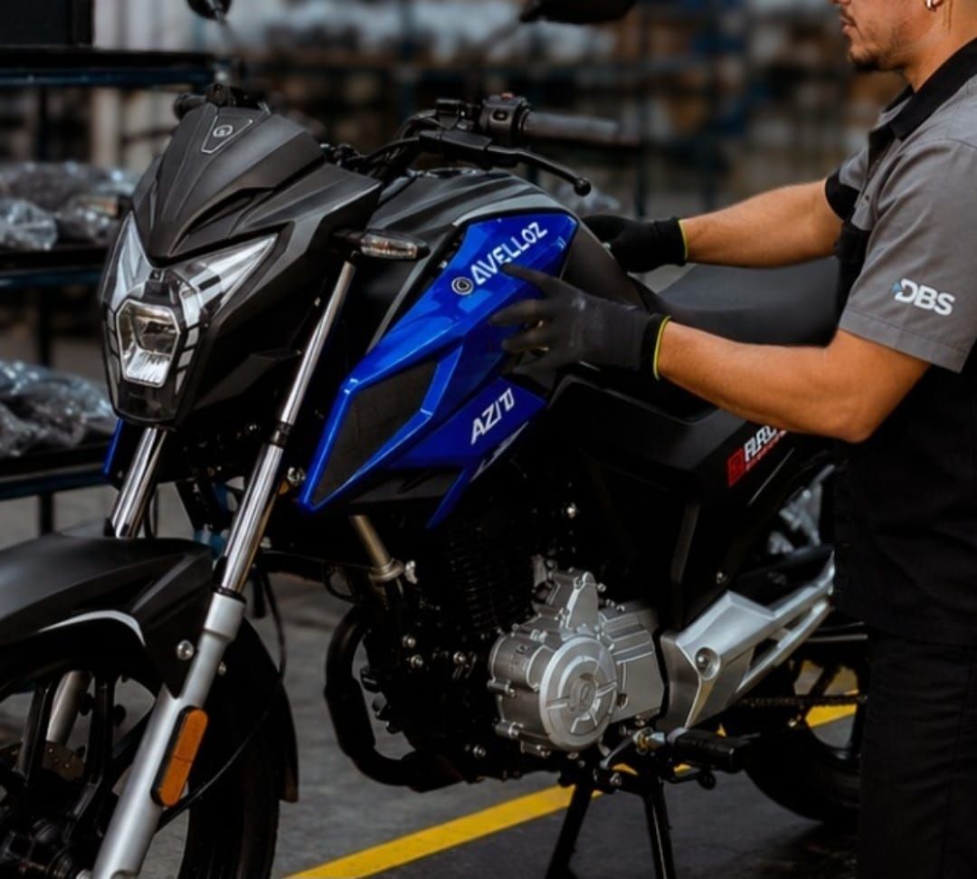 Colaborador com uniforme da DBS manuseia motocicleta azul e preta do modelo AZ170 Bravo da marca Avelloz em Manaus.