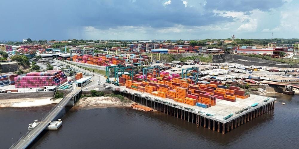 Pátio do terminal portuário Super Terminais em Manaus com centenas de contêineres coloridos empilhados à beira do Rio Negro.