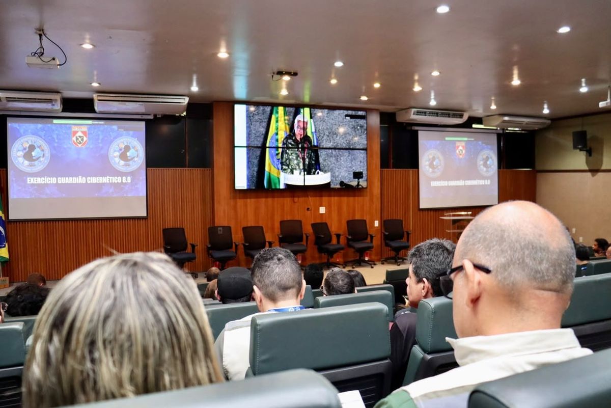 Público em auditório assiste a uma palestra exibida em telões sobre o Exercício Guardião Cibernético 8.0 na EST/UEA.