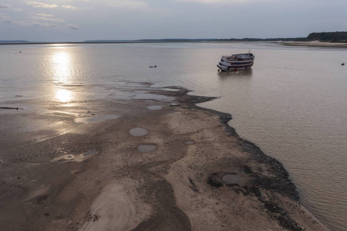 Embarcação de grande porte encalhada em banco de areia no rio Negro, em Manaus, durante período de seca severa.