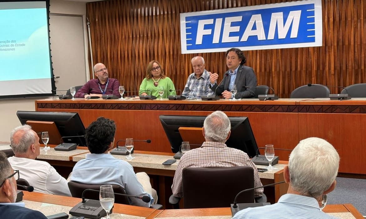 Representantes da Fieam, Sesi e OIM reunidos em mesa redonda durante encontro na sede da federação em Manaus.