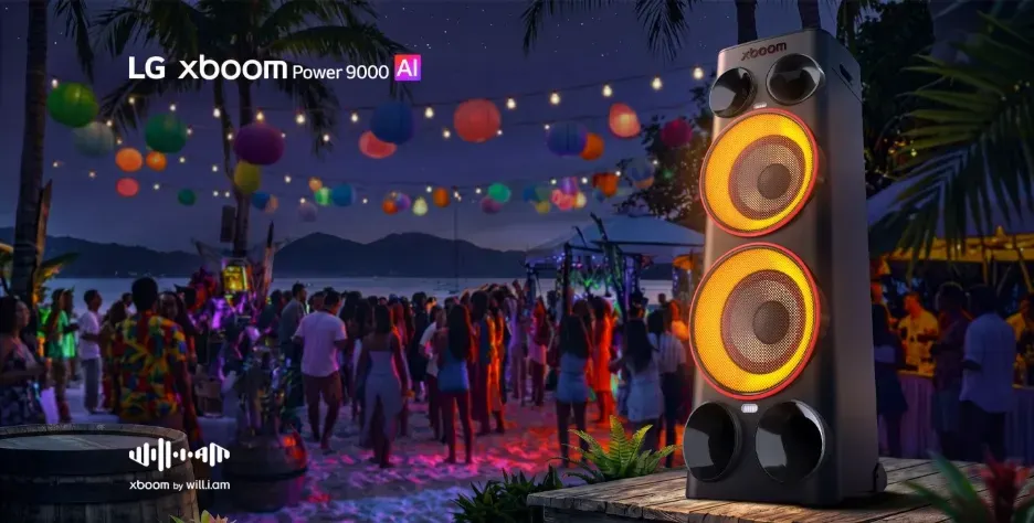 Torre de som LG xboom Power 9000 com luzes laranjas em destaque em uma festa na praia à noite.