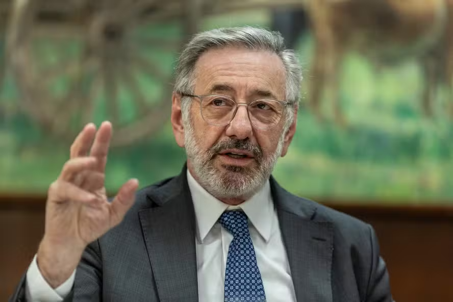 O ministro Márcio Elias Rosa, de terno cinza e gravata azul, gesticula durante fala em ambiente interno.