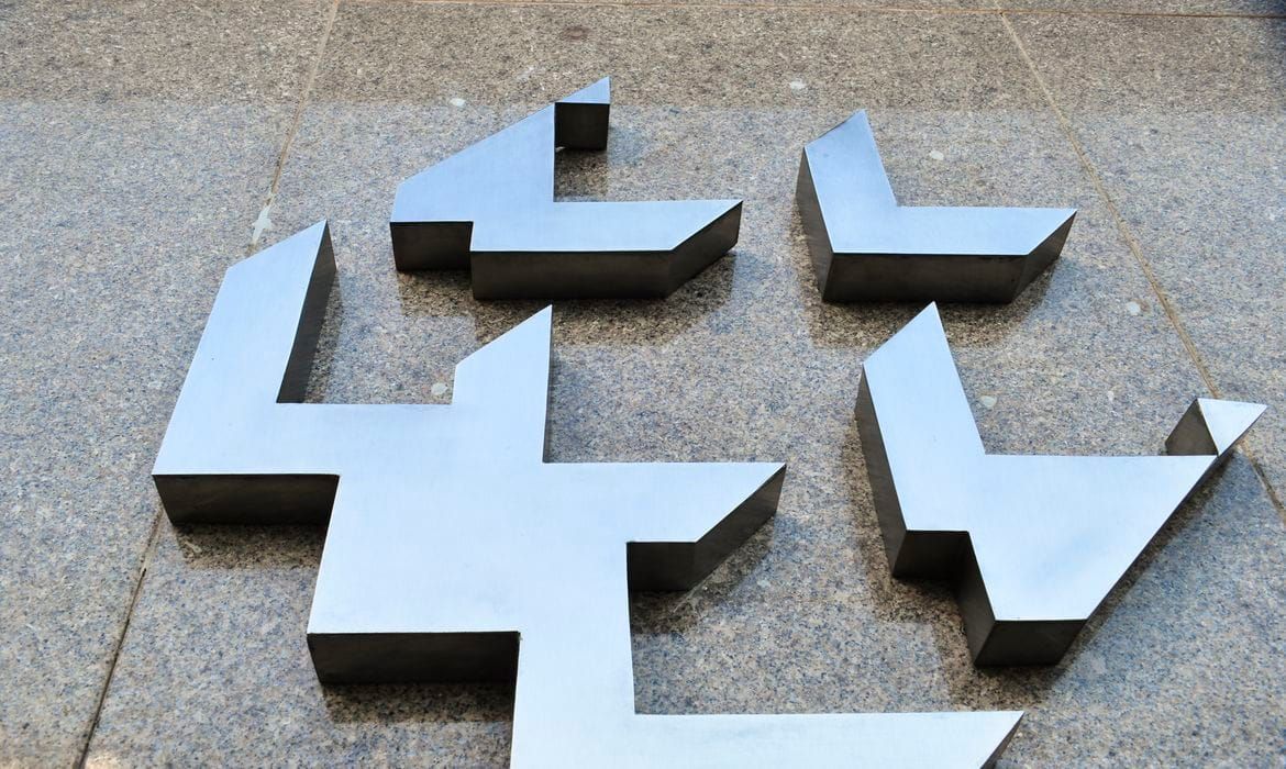 Logotipo do Banco Central do Brasil em metal fixado em uma parede de pedra cinza.