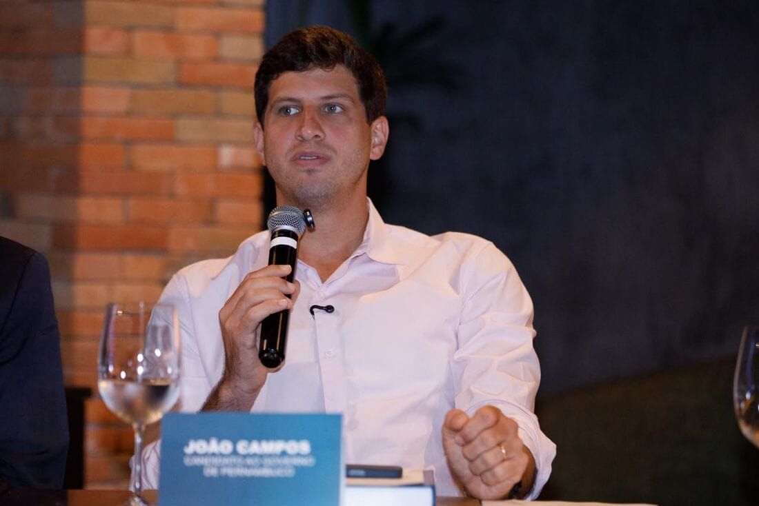 João Campos fala ao microfone durante sabatina da Câmara de Dirigentes Lojistas do Recife.