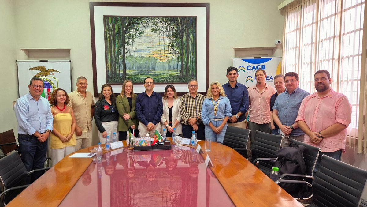 Representantes de entidades empresariais reunidos em volta de uma mesa de madeira na Associação Comercial do Amazonas.
