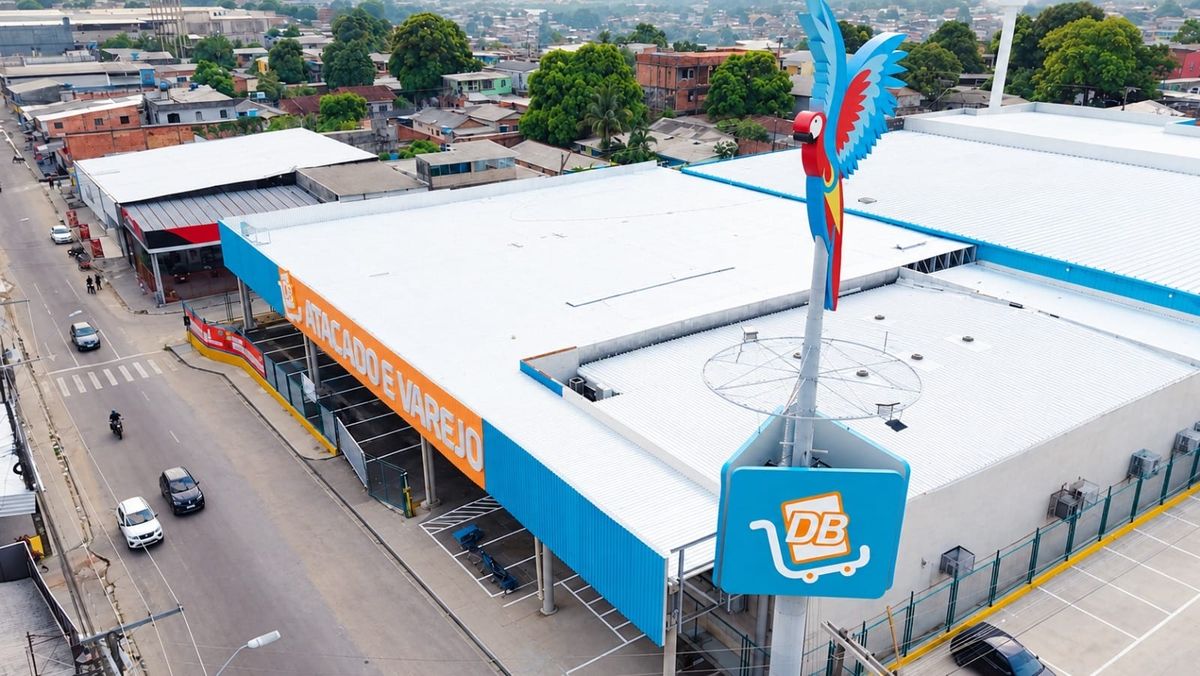 Vista aérea da fachada da unidade DB Atacado e Varejo no bairro Manoa, destacando o totem com a logomarca e uma arara.