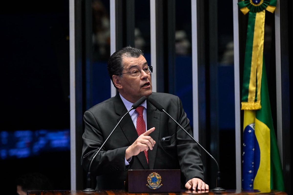 O senador Eduardo Braga discursa na tribuna do Senado Federal, vestindo terno escuro e gravata vermelha.
