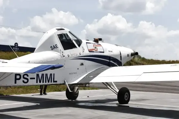 Avião branco modelo Thrush S2R-510 com prefixo PS-MML estacionado em pista, com adesivo da Defesa Civil do Amazonas.