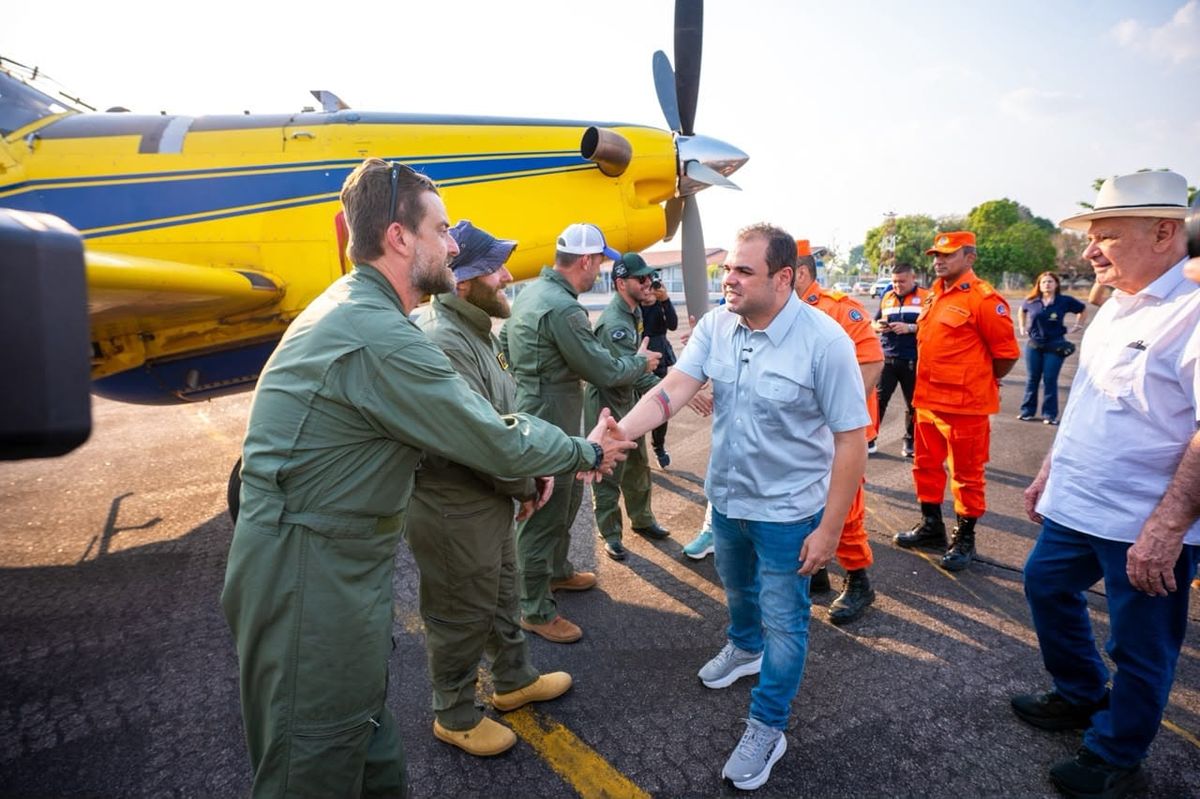 Homem cumprimenta piloto ao lado de um avião amarelo Air Tractor do Ibama em uma pista de pouso.