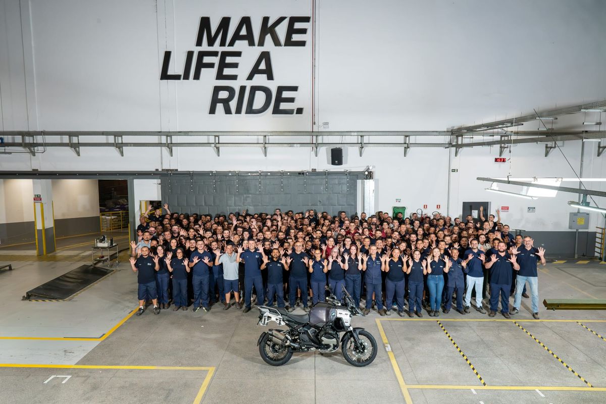 Colaboradores da BMW Motorrad posam para foto comemorativa de 10 anos da fábrica em Manaus ao lado de uma motocicleta.