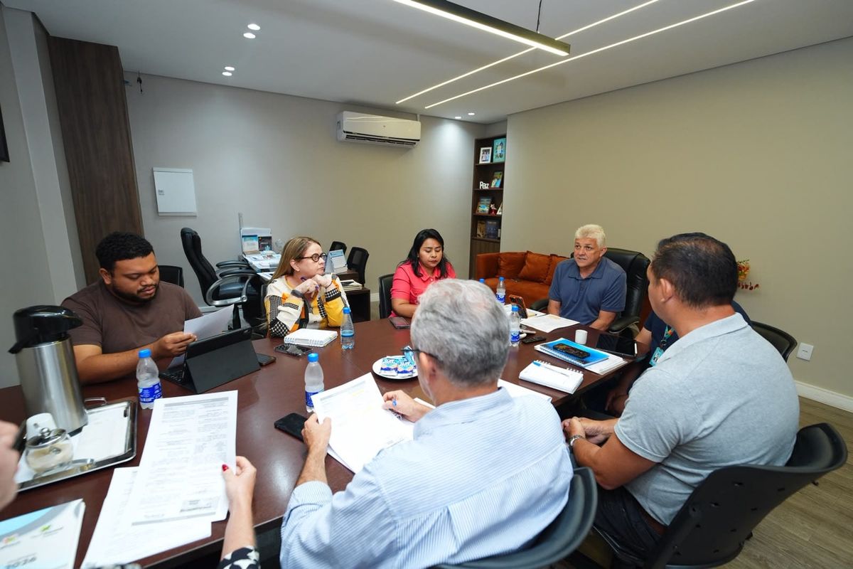 Integrantes do comitê gestor do Distrito de Inovação reunidos em volta de uma mesa de madeira na sede da Semtepi, em Manaus.