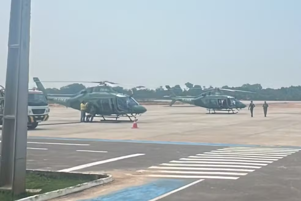Dois helicópteros verdes do Ibama estacionados na pista do Aeroporto Internacional Eduardo Gomes, em Manaus.