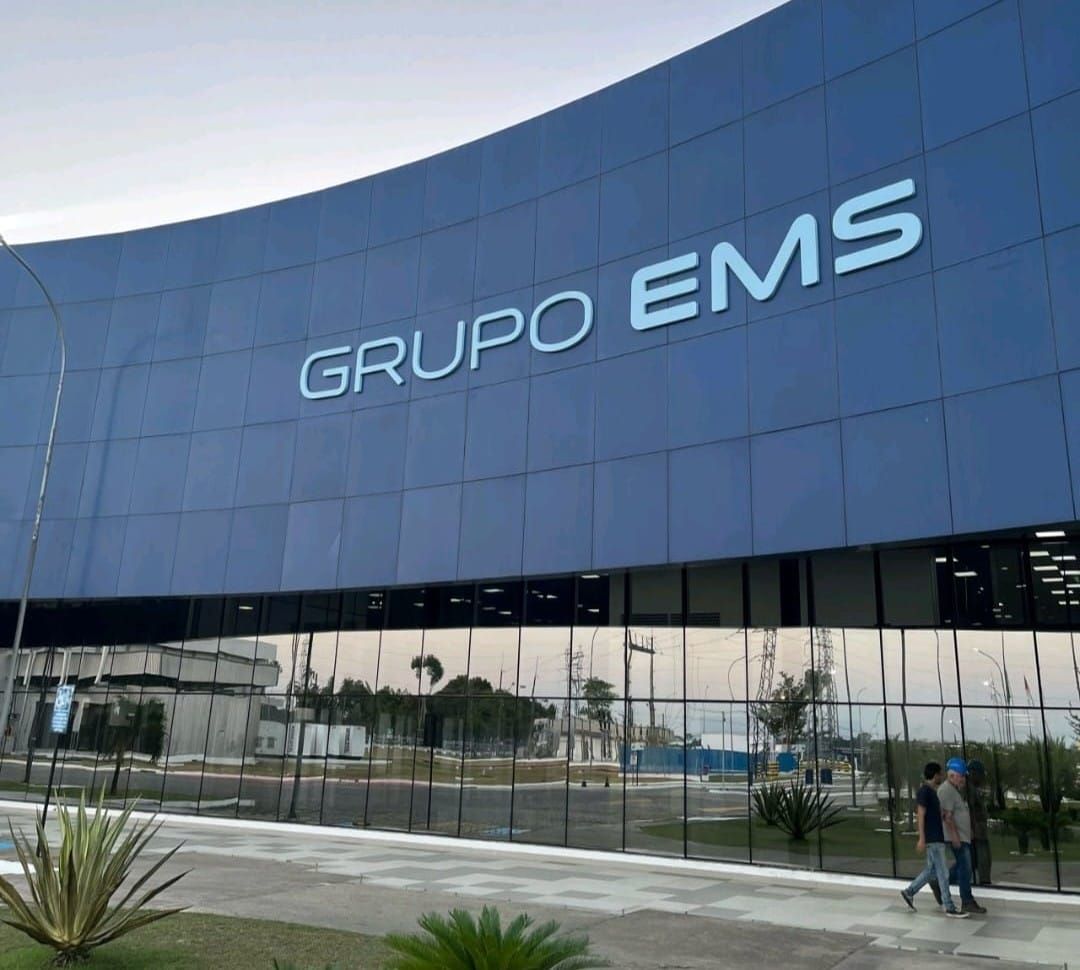 Fachada azul espelhada com o letreiro Grupo EMS em destaque, em Manaus.
