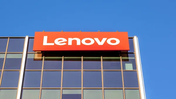Pessoa segurando um notebook da Lenovo, com um fundo desfocado que sugere um ambiente de trabalho moderno e sustentável.