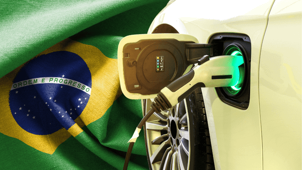 Carro elétrico azul em destaque, com a bandeira do Brasil ao fundo, representando o mercado nacional