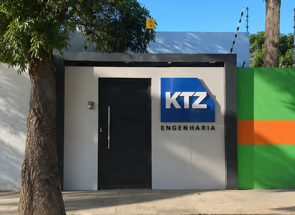Contêineres empilhados em um pátio de terminal de cargas, sob um céu azul