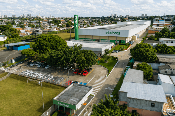 Vista aérea da fábrica da Intelbras, com telhados brancos e área verde ao redor, em Manaus