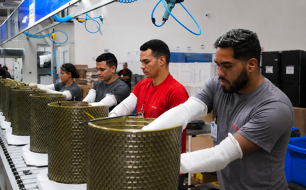 Linha de produção de ar-condicionado na fábrica da TCL em Manaus, com trabalhadores e equipamentos automatizados
