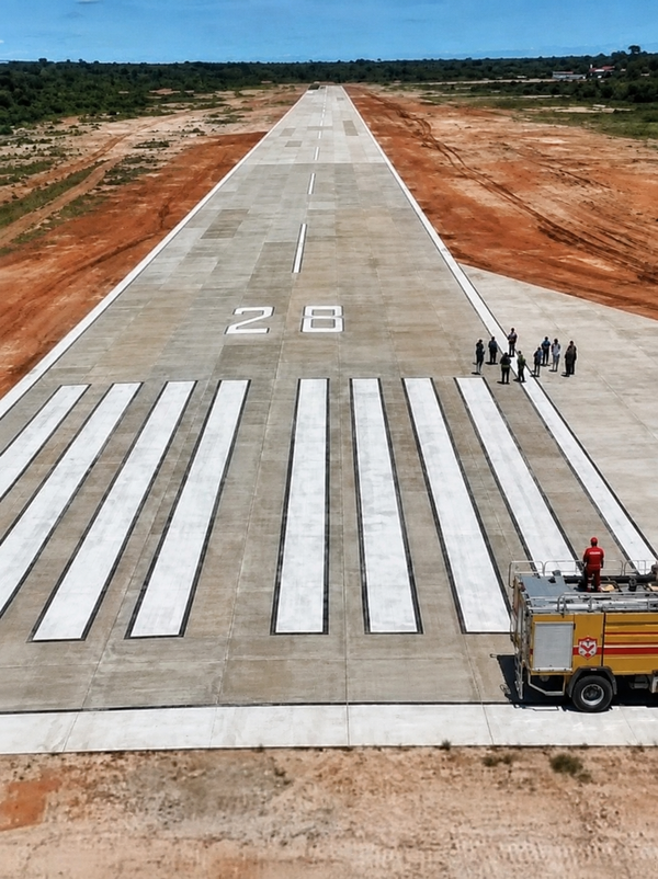 Pista de concreto do aeroporto de Coari, Amazonas, com marcações brancas e o número 28, e um caminhão de bombeiros ao lado