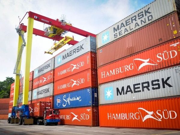 Contêineres empilhados de diversas empresas de logística, como Maersk, Hamburg Süd e Safmarine, em um terminal portuário