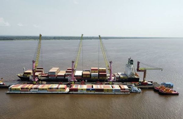 Embarcações e balsas navegando em rio na Região Norte, com margens de floresta
