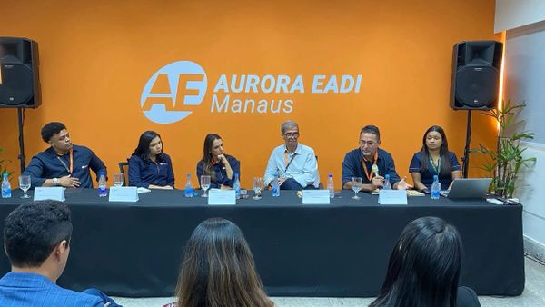 Membros da diretoria da Aurora EADI sentados em uma mesa, apresentando o sistema EIZOF e a nova gestão durante um café