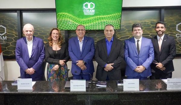 Mesa de debate com participantes de frente para a plateia, com o logo do Cieam ao fundo