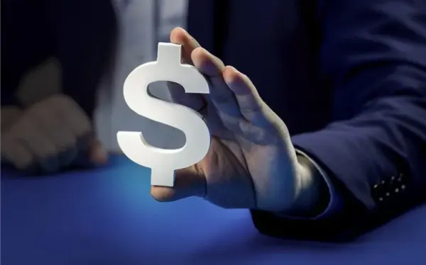 Pessoa segurando uma calculadora com notas de dinheiro ao fundo, simbolizando a Reforma Tributária