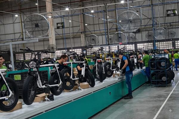 Linha de montagem da OX Bike em Manaus, com funcionários trabalhando na produção de bicicletas