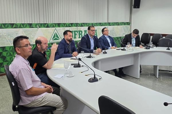 Contêineres empilhados no terminal do Super Terminais, em Manaus, com guindaste ao fundo
