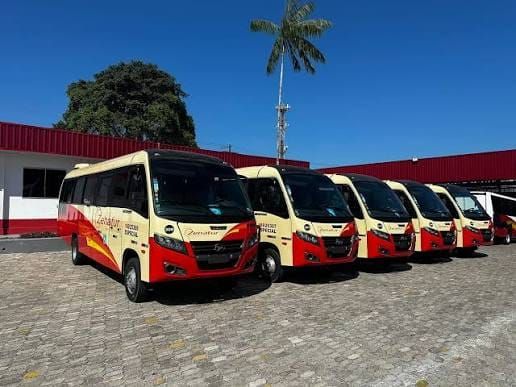 Ônibus de transporte fretado estacionados em pátio, com outros veículos ao fundo, em Manaus