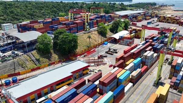 Contêineres empilhados em um terminal portuário, simbolizando importação e comércio exterior.