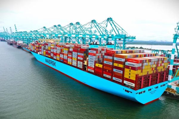 Contêineres empilhados no terminal de Buenaventura, na Colômbia, com navios de carga ao fundo