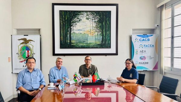 Representantes da Aporte Capital e da Associação Comercial do Amazonas reunidos em mesa de madeira em Manaus.