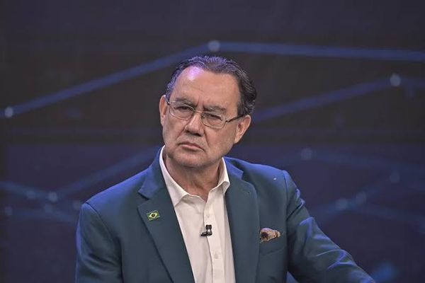 O candidato à Presidência Augusto Cury, usando óculos e paletó azul, durante participação em evento.
