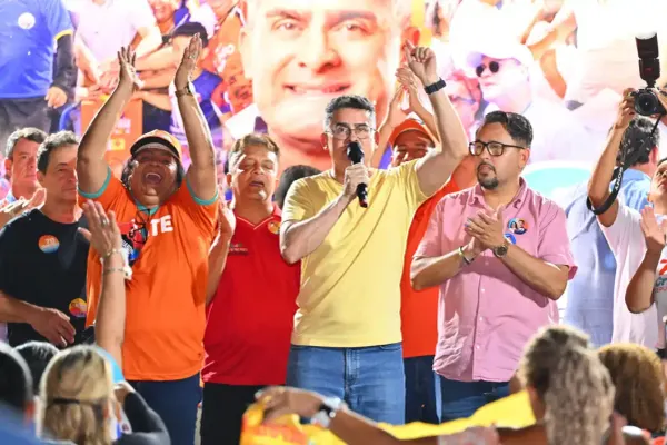 David Almeida fala ao microfone durante evento político em Manaus, cercado por apoiadores.