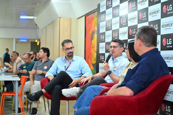 David Almeida fala ao microfone sentado em poltrona vermelha durante encontro na fábrica da LG em Manaus.