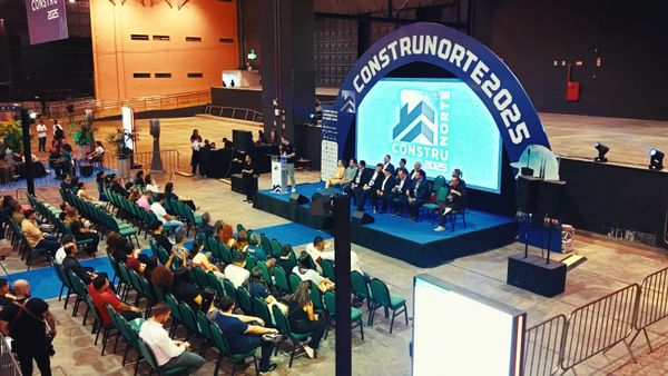 Público sentado em auditório assistindo a palestra em palco com painel da Construnorte no Studio 5, em Manaus.