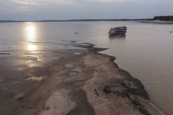 Embarcação de grande porte encalhada em banco de areia no rio Negro, em Manaus, durante período de seca severa.