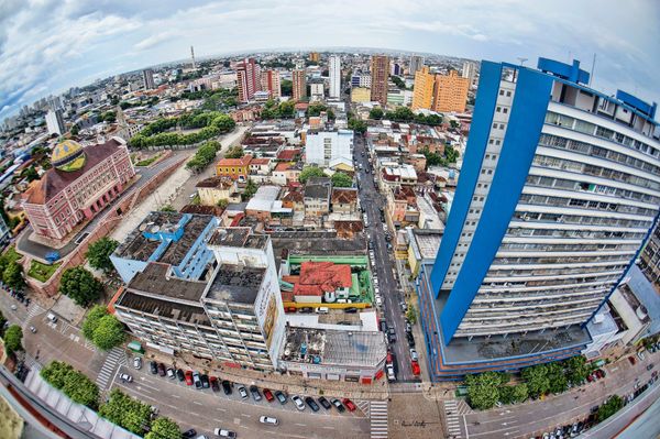 Vista aérea do Centro de Manaus com destaque para o Teatro Amazonas e prédios comerciais em perspectiva de lente olho de peixe.