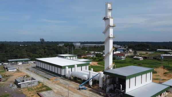 Vista aérea da unidade industrial da Gases da Amazônia em Manaus, com torre branca alta e tanques de armazenamento.