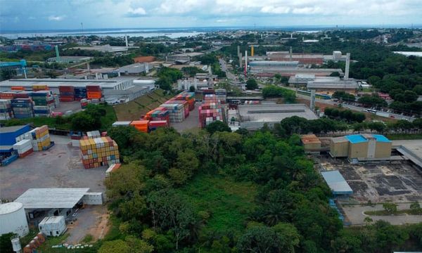 Vista aérea de galpões industriais e pátios com contêineres coloridos no Polo Industrial de Manaus.