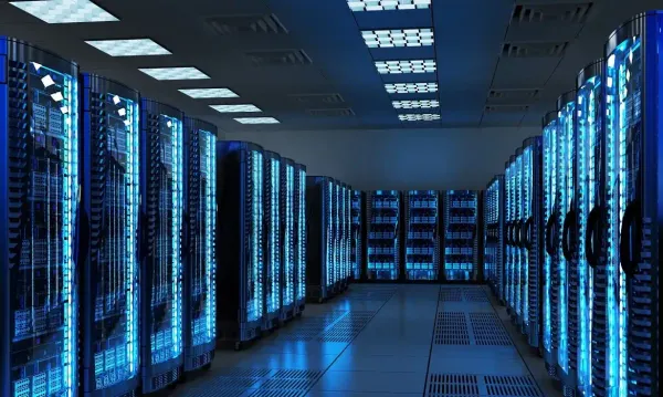 Corredor interno de um datacenter com fileiras de servidores iluminados por luzes azuis em ambiente tecnológico.